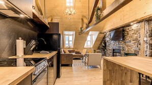 A cozy kitchen with wooden accents, a stone wall, and a fireplace. - Gorgeous 3 Bedroom 2-floor Old Townhouse (Québec)