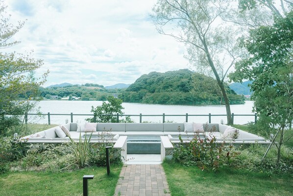 A garden with a seating area overlooking a lake and hills. - HOTEL and KOTEI SOKA (Kyotango)