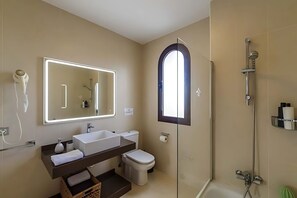 Ein modernes Badezimmer mit großem Spiegel, Waschbecken, Toilette und Duschbereich.