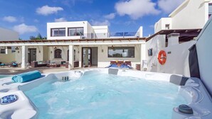 A modern building with a hot tub and outdoor seating area. - Luxury Villa with Private Pool and Stunning Views in Playa Blanca, Lanzarote (Playa Blanca)
