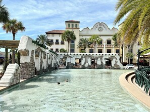 A historic building with a fountain, clear pool, and outdoor seating area.