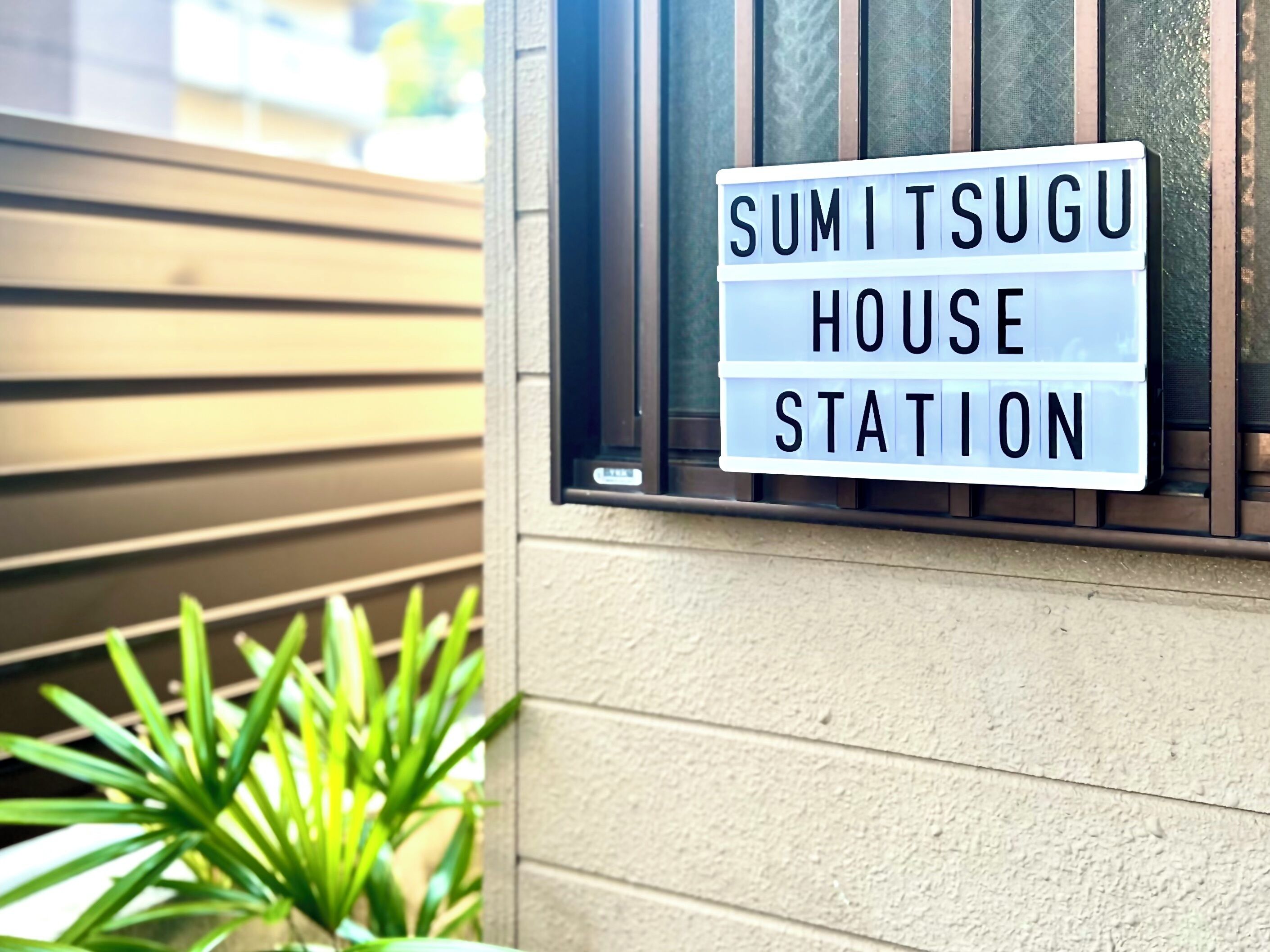 Un letrero con el texto "SUMITSUGU HOUSE STATION".