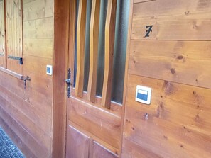 A wooden stable door with a latch, a window with vertical bars, and a number '7' on the door.