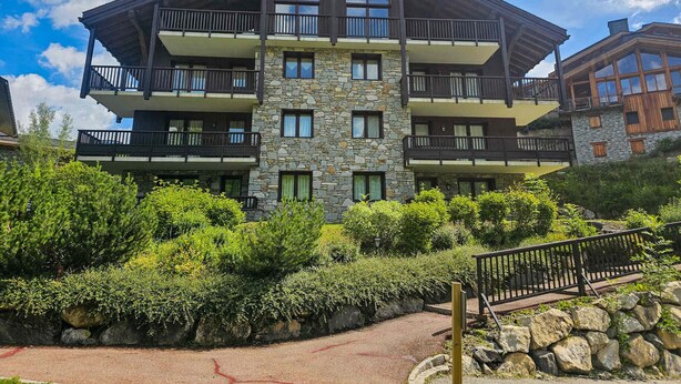 A multi-story building with balconies, stone facade, and surrounding greenery. - Comfortable apt for 6 in Saint-Martin near slopes, parking, WiFi (Saint-Martin-de-Belleville)