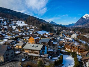 A town with a prominent hotel featuring a large roof and a ski lift.