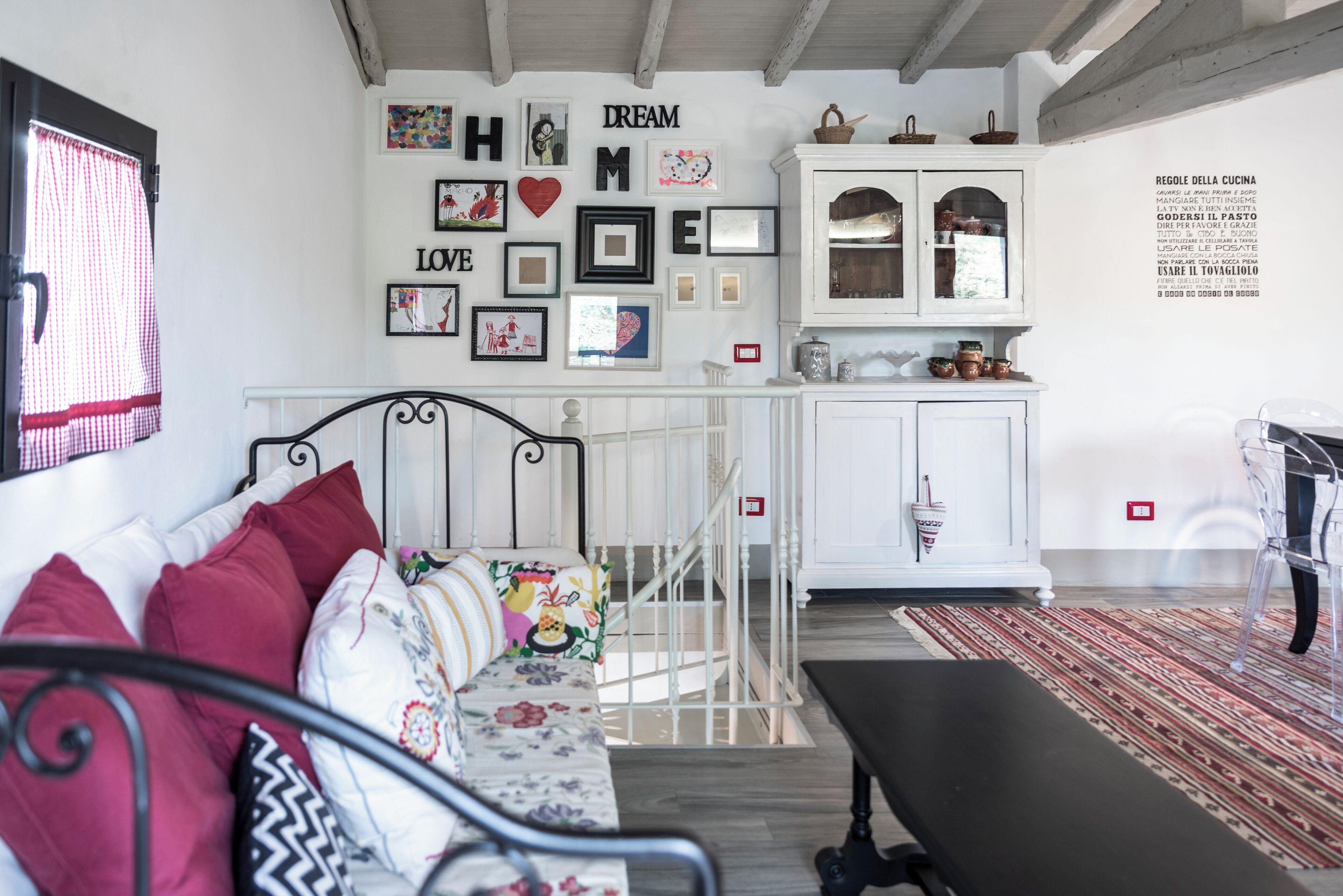 A cozy room with a bed, a bench, a dining table, and a kitchen area.