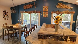 Una cocina moderna con una isla grande, sillas de madera y una mesa de comedor.