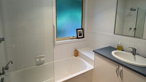 A modern bathroom with a bathtub, shower, and sink. - 'Pippa's Place'
Family friendly, newly renovated sanctuary atop Mt Little Joe (Warburton)