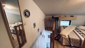 A bedroom with a bunk bed, a wooden chair, a mirror, and a wall sign. - Praz de Lys resort, duplex apartment 200 metres from the ski lifts (Taninges)