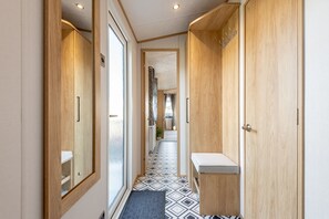 A narrow hallway with wooden doors and a tiled floor. - Lodge No 44 | Stewart's Resort Cameron (Cameron)