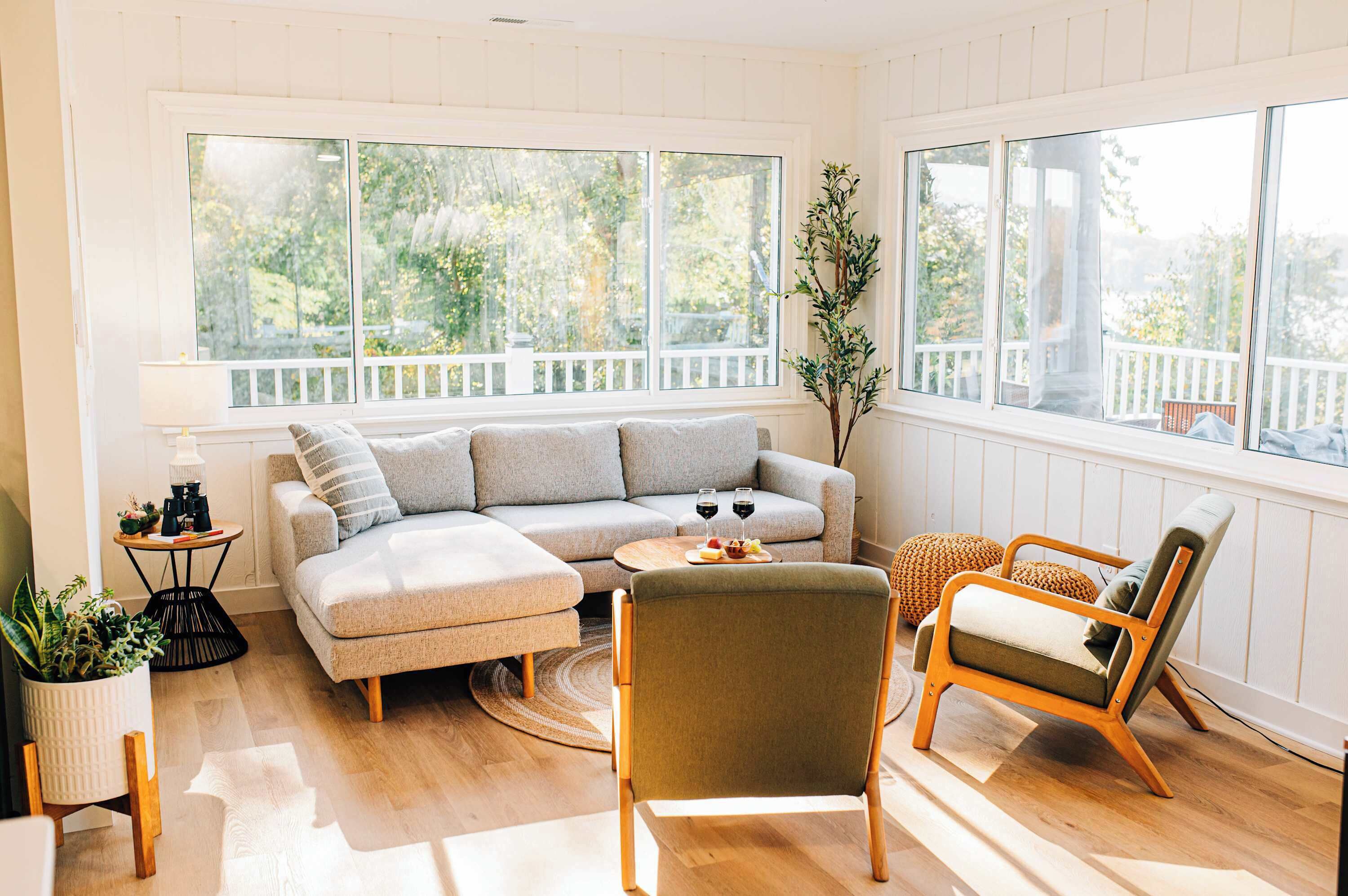 Una sala de estar acogedora con un sofá seccional, una mesa de centro de madera y un sillón verde.