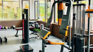 A gym with exercise equipment, a bench, and a punching bag. - Takdiri Homes Executive Studio (Nairobi)