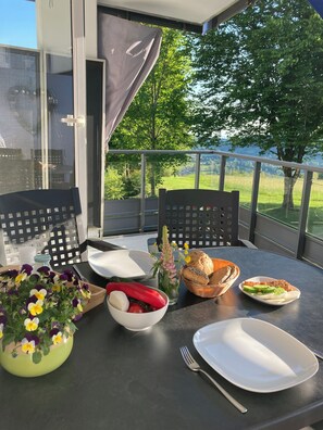 Enjoy a meal on the balcony with a view of the lush green landscape.