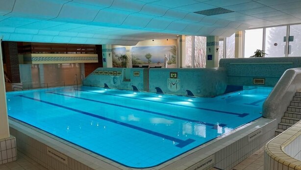 Une piscine intérieure dotée de plusieurs couloirs, d’un vestiaire et d’un espace d’accueil.