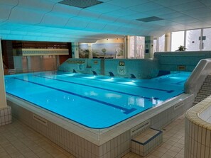 Ein Hallenbad mit mehreren Bahnen, einem Umkleideraum und einer Rezeption.
