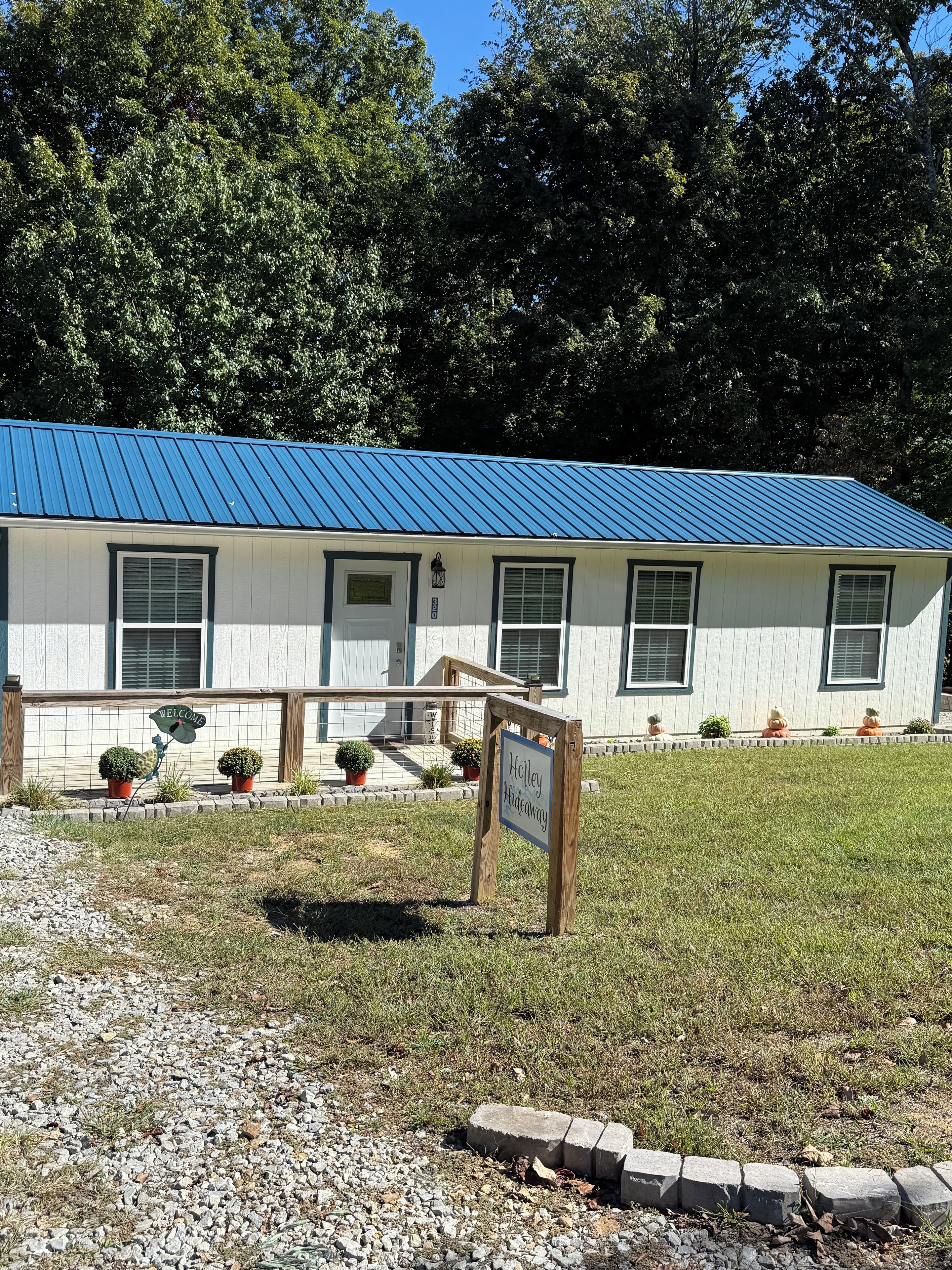 A building with a blue roof, a welcome sign, and a sign indicating 'Holly Hideaway.'