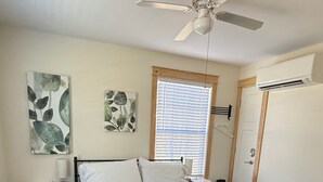 A bedroom with a bed, a nightstand, a desk, a ceiling fan, and a window with blinds. - Charming 2-bedroom, 2 full baths and pet friendly house near Mammoth Cave NP. (Mammoth Cave)