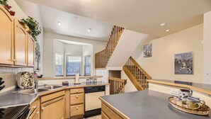 A modern kitchen with wooden cabinets, a built-in oven, and a large island. - Village Point #212: Private Hot Tub and Easy Access to Town and Slopes (Breckenridge)