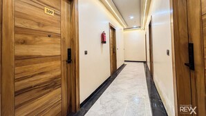 A hotel corridor with wooden doors, numbered 109, and a marble floor. - Hotel Brij Vas (Mathura)