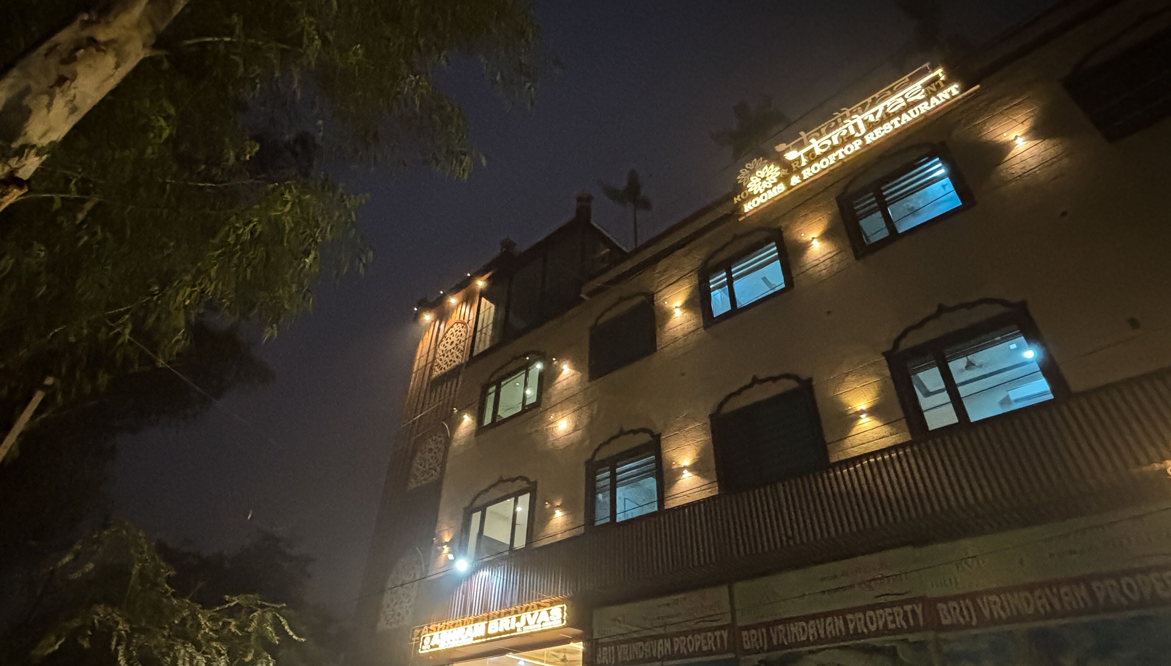 A multi-story building with illuminated signage indicating it is a restaurant and property management company.