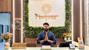 A reception desk with a sign reading "RECEPTION," a peacock logo, and a "Your first choice" sign above. - Hotel Brij Vas (Mathura)