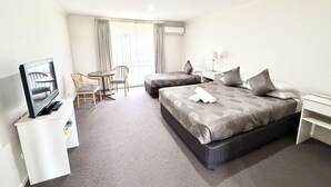 A hotel room with two beds, a TV, a desk, and a chair. - Redgum Motel (Mathoura)