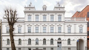 Un edificio grande, blanco y de estilo clásico con varias ventanas y una entrada central.