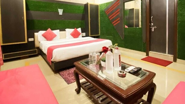 Una habitación de hotel moderna con cama, una mesita de vidrio y un ventilador de techo.