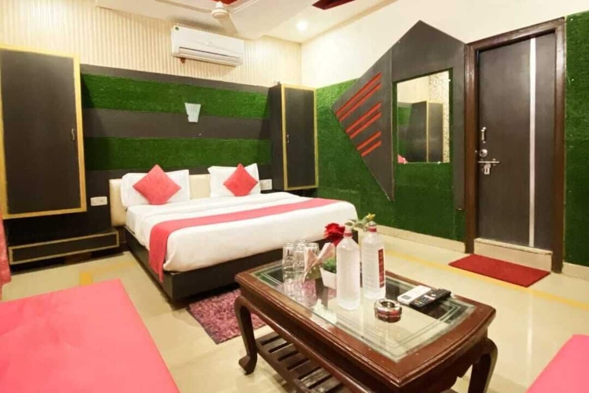 Une chambre d’hôtel moderne, équipée d’un lit, d’une table basse en verre et d’un ventilateur de plafond.