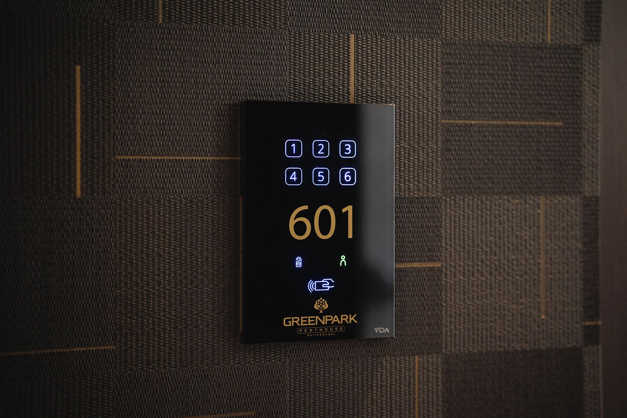 A digital keypad with the number 601 and the Greenpark logo on a textured wall.