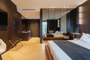 A modern hotel room with a large bed, a desk, a seating area, and a view of the city through large windows. - Green Park penthouse Suite & Pool (Bari)