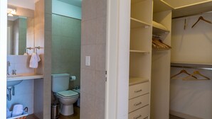 A bathroom with a toilet, sink, and a mirror.