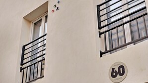 Rakennuksen julkisivussa on säleikköiset ikkunat ja kyltti, jossa lukee: ”RUE DES 60 ENTREPIÔTIS”.