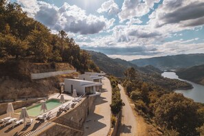 Un hotel moderno con piscina, con vistas a un valle y un lago.