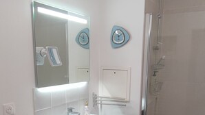 Une salle de bain moderne avec un meuble-lavabo, un miroir et une douche.