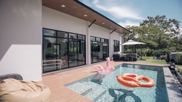 A modern house with a swimming pool, a patio, and a large glass door leading to a deck. - Issara Private Pool Villa Khaoyai A (Pak Chong)