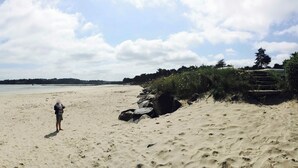 A wide sandy beach with footprints and rocks, a clear sky, and a distant view of the sea. - Brittany, Locquirec, vacation home 300m from the beach  (Locquirec)