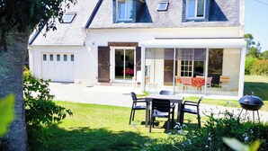 A two-story house with a large patio area, a dining table with chairs, and a barbecue grill. - Brittany, Locquirec, vacation home 300m from the beach  (Locquirec)
