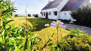 A white house with a sloped roof, a well-maintained lawn, and a clear sky. - Brittany, Locquirec, vacation home 300m from the beach  (Locquirec)