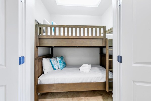 A bunk bed in a room with white walls and a skylight. - Adagio D-304 Poolside 3/3 with a Beautiful Pool View! (Santa Rosa Beach)