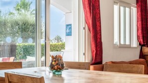 A dining area with a wooden table and chairs, a bowl of nuts, and a view of the outdoors through a glass door. - Casa Viv - Beautiful Spacious 2 bed apartment in the lovely La Torre Golf Resort (Torre-Pacheco)