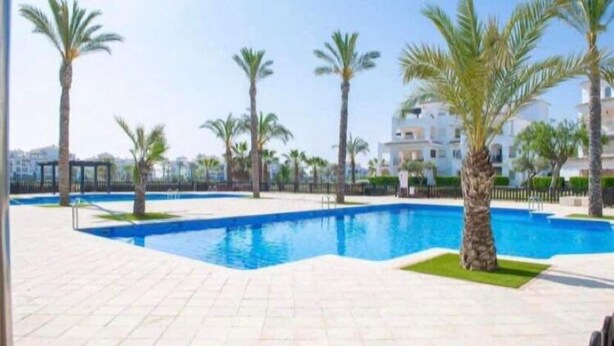 A swimming pool surrounded by palm trees and a clear sky. - Casa Viv - Beautiful Spacious 2 bed apartment in the lovely La Torre Golf Resort (Torre-Pacheco)
