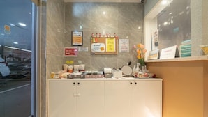 A reception desk with a bulletin board, a mirror, and various items on the counter. - Hotel Nine (Uiwang)