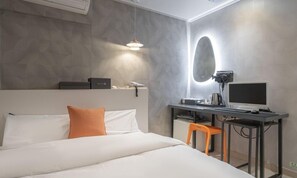 A modern hotel room with a bed, a desk with a computer, and a mirror. - Hotel Nine (Uiwang)