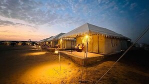 A desert camp with tents, each with a small outdoor seating area and a covered walkway. - Osaka Desert Safari Camp (Jaisalmer)