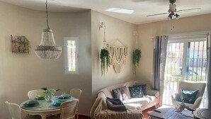 Un coin repas avec une table ronde et des chaises, un canapé et un ventilateur de plafond.