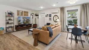 Een moderne woonkamer met een bank, salontafel en eethoek.
