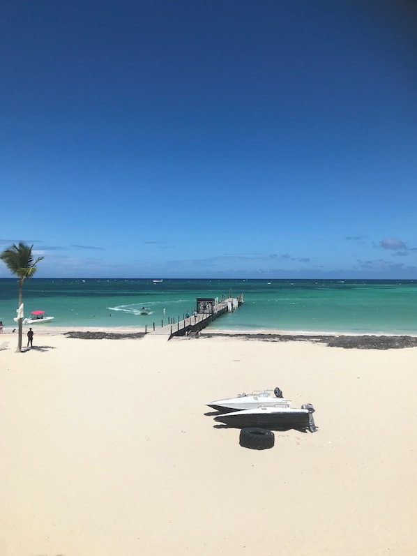 Enjoy a serene beach experience with a wooden pier, perfect for water activities and relaxation.