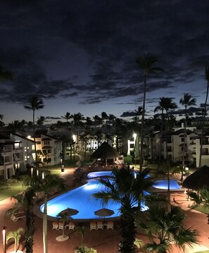 Relax by the pool surrounded by palm trees and lounge chairs.