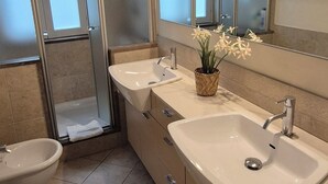A modern bathroom with two sinks, a bidet, and a shower. - Borgo San Frediano Hideaway  (Florence)